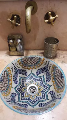a blue and white plate on a counter with a sink at Riad Sabbah in Marrakech