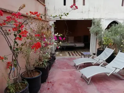 a patio with chairs and flowers in a courtyard at Riad Sabbah in Marrakech