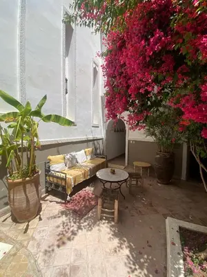 a living room with a couch and pink flowers at Private house Riad Arlette exclusive in Marrakech