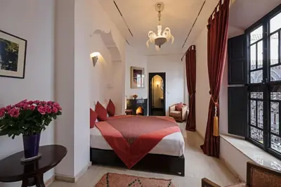 a bedroom with a bed and a table in a room at Riad Azzar in Marrakech