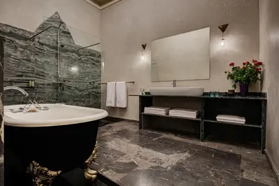 a bathroom with a tub and a sink and a mirror at Riad Siwan in Marrakech