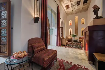 a living room with a chair and a table at Riad Siwan in Marrakech