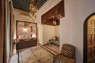 a bedroom with a bed and a chair in a room at Riad Siwan in Marrakech