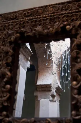 a mirror with a reflection of a bunch of chandeliers at Riad Siwan in Marrakech