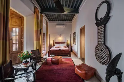 a hotel room with a bed and a living room at Riad Siwan in Marrakech