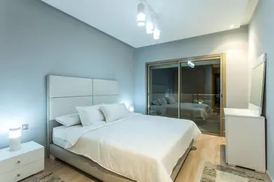 a bedroom with a large white bed and a bathroom at Prestigia 16 in Marrakech