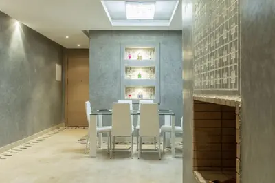 a dining room with a table and white chairs at Prestigia 16 in Marrakech