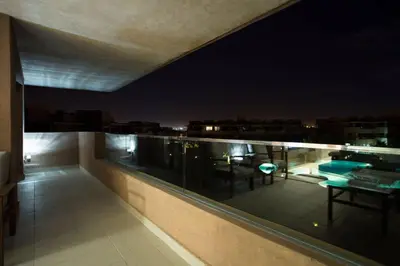 a balcony with a view of a city at night at Prestigia 16 in Marrakech
