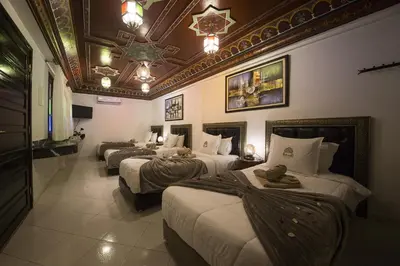 a row of four beds in a hotel room at Riad Challa Hotel & Spa in Marrakech