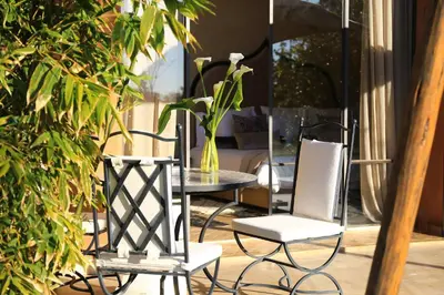 a patio with a table and chairs and a vase at Dar Sofil - Adults Only in Marrakech