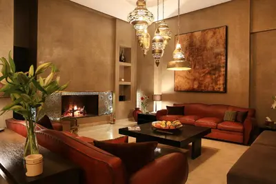 a living room with red couches and a fireplace at Dar Sofil - Adults Only in Marrakech