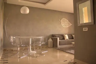 a living room with a table and a couch at Prestigia Golf City Apartment in Marrakech