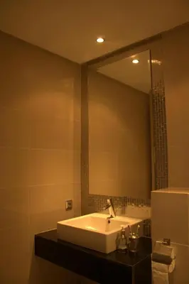 a bathroom with a sink and a large mirror at Prestigia Golf City Apartment in Marrakech