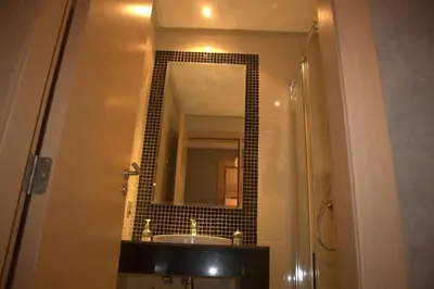a bathroom with a sink and a mirror at Prestigia Golf City Apartment in Marrakech