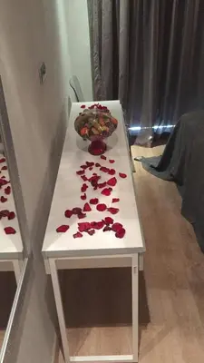 a white table with petals on it with a bowl on it at Prestigia Golf City Apartment in Marrakech