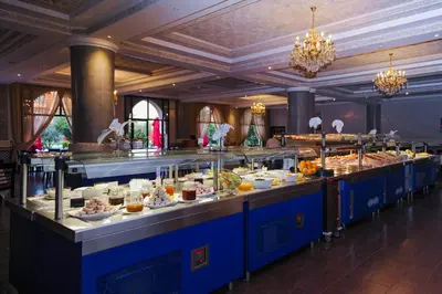 a buffet line with many plates of food at Ennakhil Marrakech Hotel & SPA in Marrakech