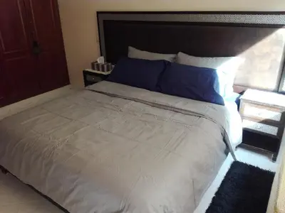 a bedroom with a large bed with blue pillows at Kim Apartment in Marrakech