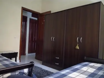 a bedroom with a large wooden cabinet and a bed at Kim Apartment in Marrakech