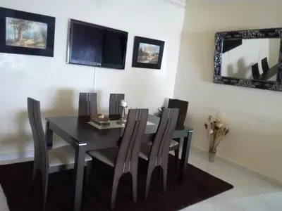 a dining room with a table and chairs and a mirror at Kim Apartment in Marrakech