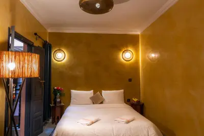 a bedroom with a bed with two towels on it at Riad Abjaou in Marrakech