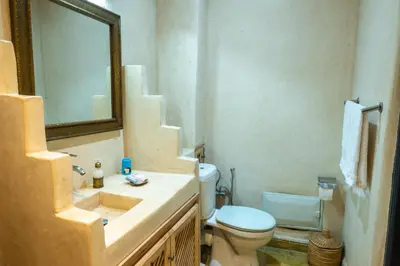 a bathroom with a sink and a toilet and a mirror at Riad Abjaou in Marrakech