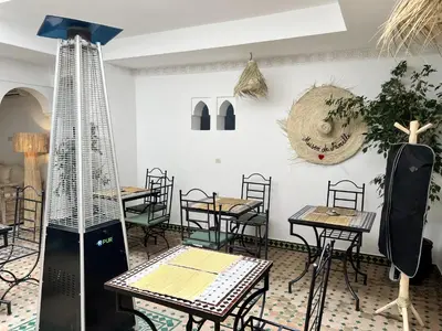 a restaurant with tables and chairs in a room at Riad Sarah Sabrina in Marrakech