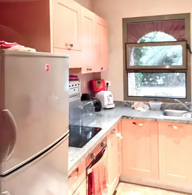 a kitchen with wooden cabinets and a stainless steel refrigerator at Comfortable Apartment in Marrakech with Shared Pool, 124 sqm in Marrakech