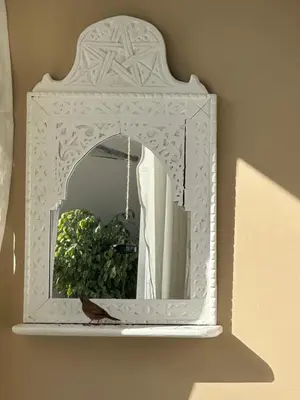 a mirror with a white frame on a wall at Riad Zeitoun Palace in Marrakech