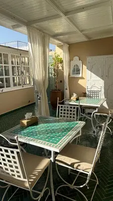 a patio with a table and chairs on a porch at Riad Zeitoun Palace in Marrakech