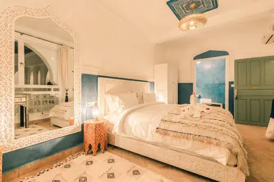 a bedroom with a large bed and a large mirror at Riad Zeitoun Palace in Marrakech