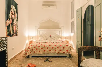 a bedroom with a bed with a white headboard at Riad Zeitoun Palace in Marrakech