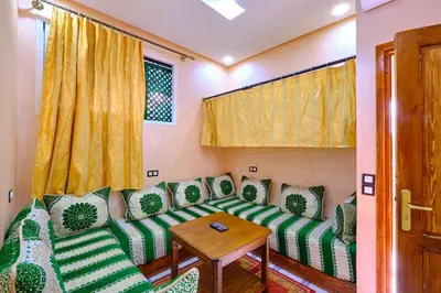 a living room with a green couch and a wooden table at Hotel Central Palace in Marrakech