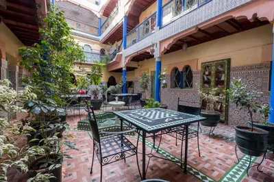 a patio with a table and chairs in a building at Hotel Central Palace in Marrakech