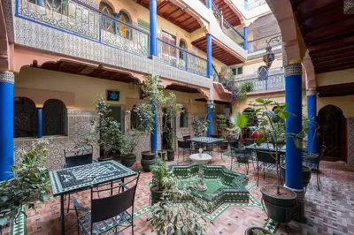 an indoor courtyard with tables and potted plants at Hotel Central Palace in Marrakech