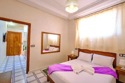 a bedroom with a bed with a bow on it at Hotel Central Palace in Marrakech