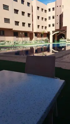 a table in front of a large building at Mouzdalifa Apartment In City Center in Marrakech