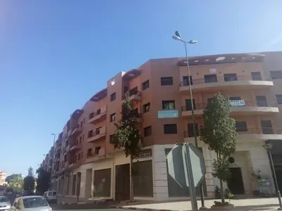 a large apartment building on a street with a stop sign at Mouzdalifa Apartment In City Center in Marrakech
