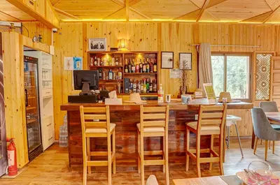a kitchen with a bar with chairs and a television at Ferme Sidi Safou & Spa in Marrakech