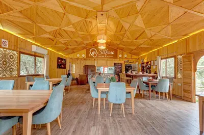 a restaurant with wooden ceilings and wooden tables and chairs at Ferme Sidi Safou & Spa in Marrakech