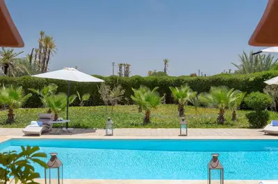 a swimming pool in a resort with an umbrella at La Palmeraie De L'Atlas in Marrakech