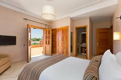 a bedroom with a large bed and a television at La Palmeraie De L'Atlas in Marrakech