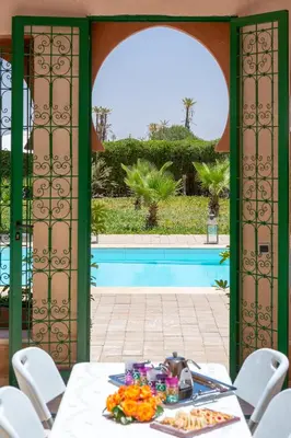 a table with flowers on it with a view of a pool at La Palmeraie De L'Atlas in Marrakech