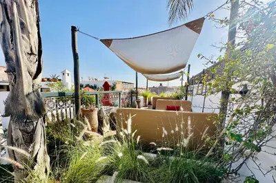 a patio with a table and a umbrella and some plants at Riad Jardin Des Sens & Spa in Marrakech