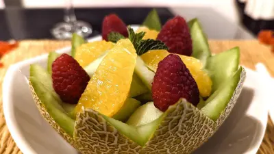 a fruit salad in a bowl on a white plate at Riad Jardin Des Sens & Spa in Marrakech