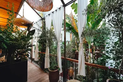 a balcony with white umbrellas and potted plants at La Ferme Medina in Marrakech