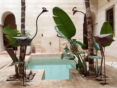 a swimming pool with trees and plants in a house at Dar al Sultan in Marrakech