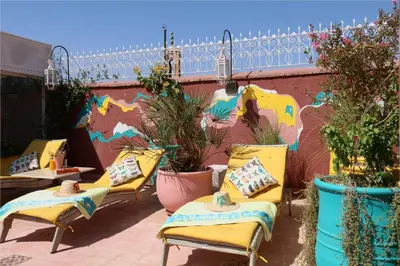 a group of chairs sitting on a patio with plants at Riad Karmela Princesse in Marrakech