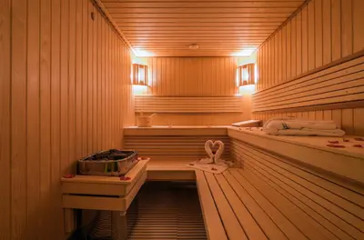 a sauna with wooden walls and a tub with a thermometer at Hotel Ayoub & Spa in Marrakech