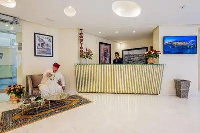 a woman sitting on a couch in a lobby at Hotel Ayoub & Spa in Marrakech