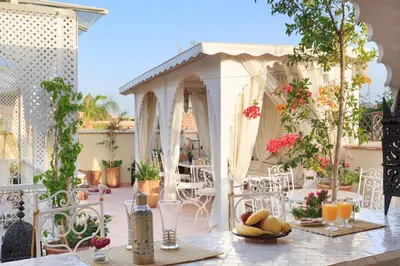 a patio with a table with fruit on it at Astra Damus Hotel in Marrakech